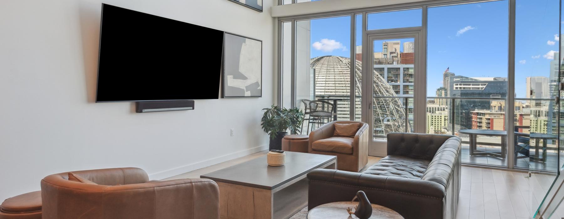 a living room with a tv couch chairs and a large window